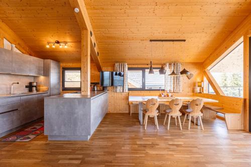 a kitchen with wooden ceilings and a table and chairs at Alpenchalets Reiteralm by ALPS RESORTS in Schladming