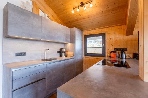 a kitchen with a sink and a counter top at Alpenchalets Reiteralm by ALPS RESORTS in Schladming