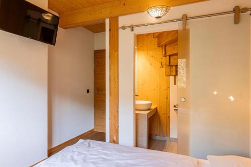 a bedroom with a bed and a bathroom at Alpenchalets Reiteralm by ALPS RESORTS in Schladming