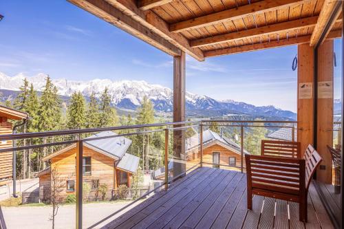 a wooden deck with a bench on a balcony with mountains at Alpenchalets Reiteralm by ALPS RESORTS in Schladming