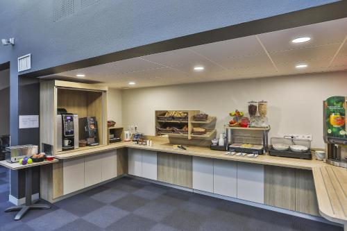 a kitchen with a counter in a cafeteria at ACE Hôtel Vendée Saint Hermine in Sainte-Hermine