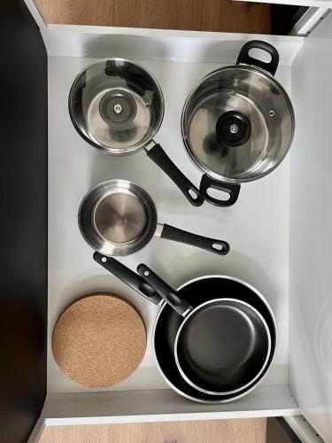 a kitchen with four pots and pans in a drawer at ENDLESS: Studio mit Netflix + Workstation im Zentrum in Schwerin