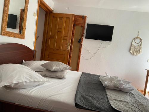 een slaapkamer met een bed en een televisie aan de muur bij Pensiunea Bianca in Bran