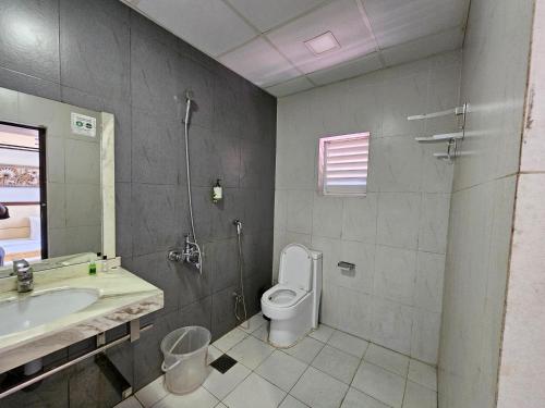 La salle de bains est pourvue de toilettes et d'un lavabo. dans l'établissement ADRAK BOUTIQUE HOTEL, à Trivandrum