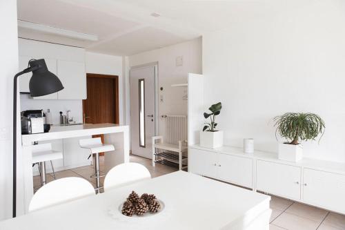eine weiße Küche mit einem weißen Tisch und Stühlen in der Unterkunft Residenza la Promenada App 4242 in Orselina