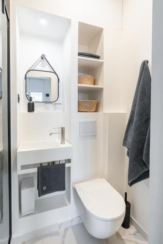 une salle de bain blanche avec des toilettes et un lavabo dans l'établissement La Suite Le Marais, à Paris