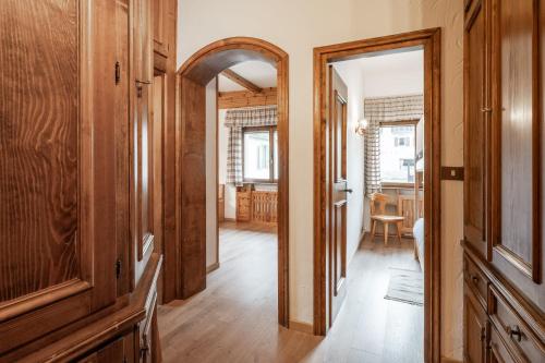 pasillo con espejo y habitación con mesa en Lovely 2 bedroom flat in Corso Italia with parking, en Cortina dʼAmpezzo