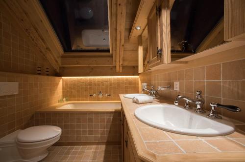 a bathroom with a sink and a toilet at Hotel Olden in Gstaad