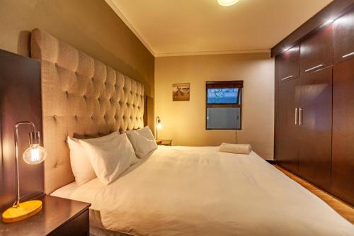 ein Schlafzimmer mit einem großen Bett mit großem Kopfteil in der Unterkunft Modern 1 Bedroom Apartment No Loadshedding in Kapstadt