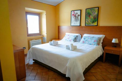 a bedroom with a large white bed with a window at L'Antico Gabbiano B&B in San Casciano in Val di Pesa