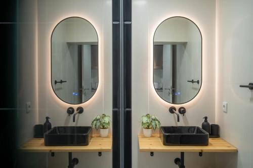 a bathroom with two sinks and two mirrors at OASIS Avenida da República in Vila Nova de Gaia