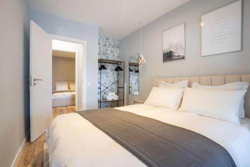 a bedroom with a large bed with white pillows at OASIS Avenida da República in Vila Nova de Gaia