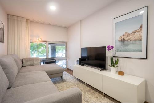 a living room with a couch and a flat screen tv at OASIS Avenida da República in Vila Nova de Gaia