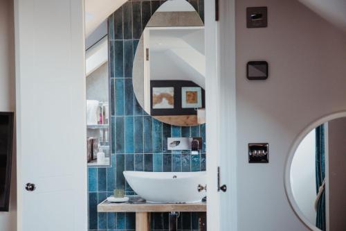 ein Badezimmer mit Waschbecken und Spiegel in der Unterkunft Marners Rock No 2 in Fowey