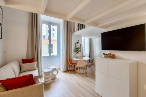 Sala de estar blanca con sofá y mesa en SUEDE PROMENADE Duplex apartment at 1 min from the sea 2 baths, en Niza