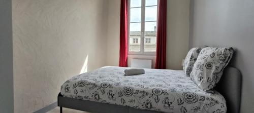 1 dormitorio con silla y ventana en - Meublés de Beaulieu cœur de ville - en Angoulême