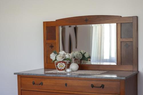 a dresser with a mirror and a vase with flowers at Villa Fabiana in Torre dell'Orso