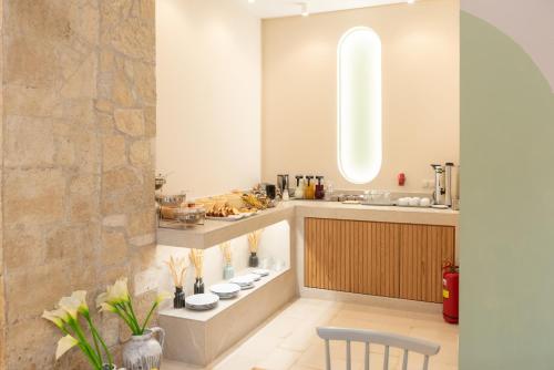 a kitchen with a counter with a sink and a chair at Lino Mare Boutique Hotel in Amoudara Herakliou