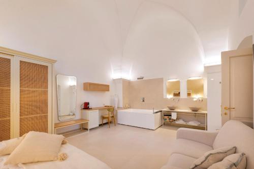 een grote witte kamer met een bank en een wastafel bij Il Nido Luxury Suites in Montesano Salentino