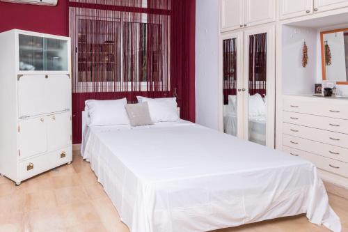 a white bedroom with a white bed and red walls at Havre de Paix in Tunis