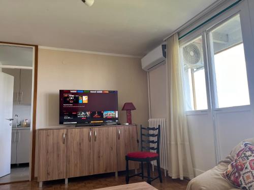 a living room with a flat screen tv on a wooden cabinet at Comfort & Style Panoramic Urban Retreat in Novi Beograd