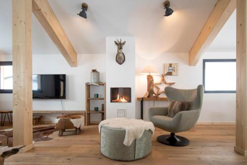 a living room with a chair and a tv at Alpenchalets Reiteralm by ALPS RESORTS in Schladming