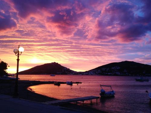 a sunset over a body of water with boats in it at Atlazia Suites in Alinda