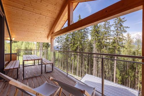 a screened in porch with chairs and a table at Alpenchalets Reiteralm by ALPS RESORTS in Schladming