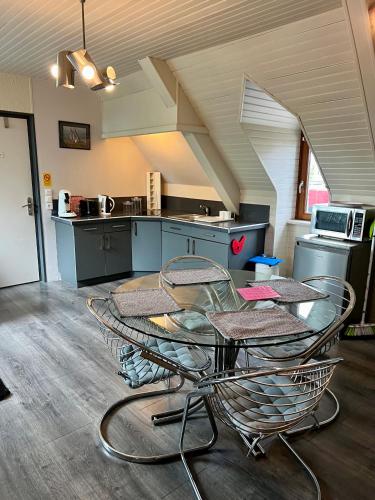 une cuisine avec une table et des chaises dans une pièce dans l'établissement Appart'hotel Maison Saint Michel, à Paimpol