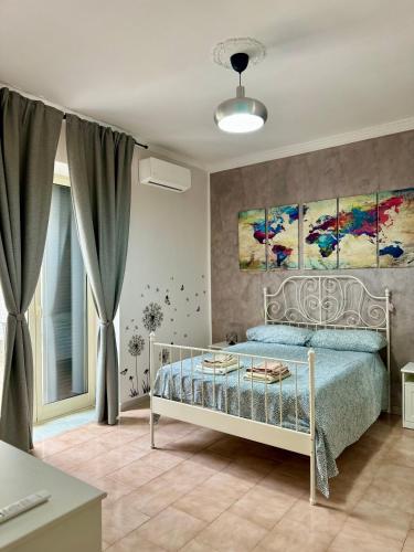 1 dormitorio con 1 cama y pinturas en la pared en Casa Affitto Breve Frattamaggiore, en Frattamaggiore