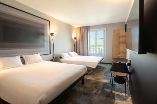 a hotel room with two beds and a window at ibis Strasbourg Centre Gare in Strasbourg