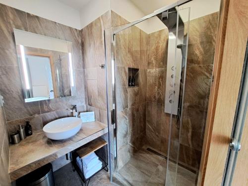 W łazience znajduje się szklana kabina prysznicowa i umywalka. w obiekcie Hotel Frýdl w Pradze