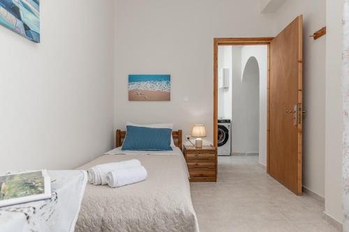 a bedroom with a bed and a door to a bathroom at Villa Grevillea Mikri Vigla in Mikri Vigla