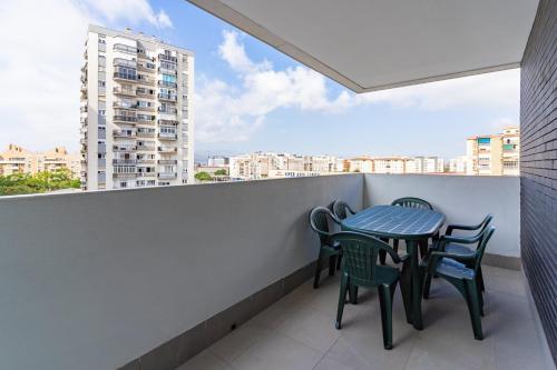 einen Tisch und Stühle auf einem Balkon mit Blick auf ein Gebäude in der Unterkunft GuestReady - Sunny Seaside Escape in Málaga in Málaga