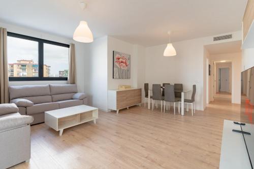 ein Wohnzimmer mit einem Sofa und einem Tisch in der Unterkunft GuestReady - Sunny Seaside Escape in Málaga in Málaga