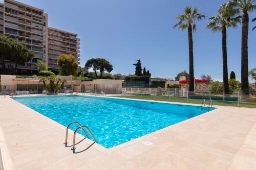 une piscine vide avec des palmiers en arrière-plan dans l'établissement Jolie studio cosy proche mer sur Juan les pins, à Antibes