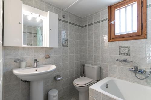 a bathroom with a sink and a toilet and a tub at Villa Grevillea Mikri Vigla in Mikri Vigla
