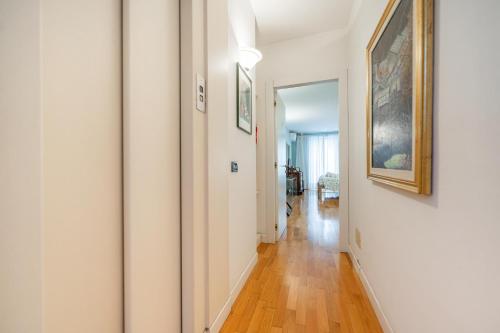 a hallway with white walls and wood floors and paintings at B&B Corso Mazzini 22 - Between Verona & Garda Lake in Bussolengo