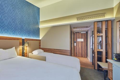 a hotel room with a large bed and a television at L'Elysée Val d'Europe in Serris