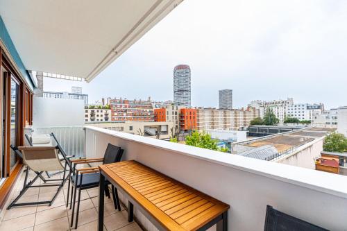 un balcon avec un banc en bois et des chaises sur un immeuble dans l'établissement GuestReady - Apt avec Balcon à la Place d'Italie, à Paris