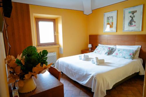 a bedroom with a large white bed and a window at L'Antico Gabbiano B&B in San Casciano in Val di Pesa