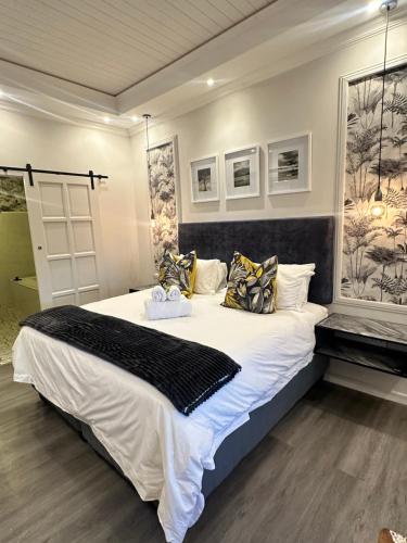 a bedroom with a large bed with white sheets and pillows at Spacube Luxury Suites and Spa in Pretoria