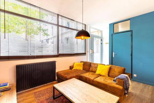 un salon avec un canapé marron et une table dans l'établissement GuestReady - Apt de Charme près de la Tour Eiffel, à Paris
