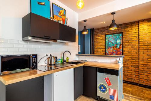 une cuisine avec un évier et un micro-ondes dans l'établissement GuestReady - Apt de Charme près de la Tour Eiffel, à Paris