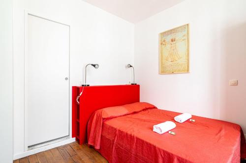 - un lit rouge dans une chambre dotée d'un couvre-lit rouge dans l'établissement GuestReady - Charming stay near Belleville, à Paris