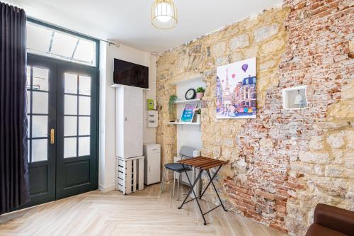 Cette chambre est dotée d'un mur en briques et d'une table. dans l'établissement GuestReady - Charming Getaway in Le Marais, à Paris