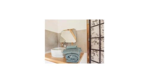 uno specchio su un tavolo con lampada e asciugamani di Le Loft, chambre triple - Gîte de la Louve a Fougax-et-Barrineuf