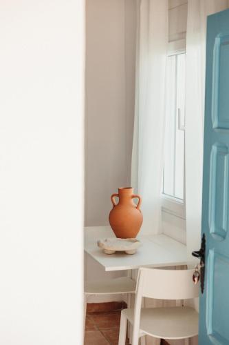 a vase sitting on a table next to a window at Los Bungalows Del Arenal in Jávea