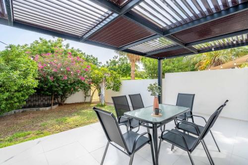 a patio with a table and chairs under a pergola at GuestReady - Springs Serenity near Golf Club in Dubai