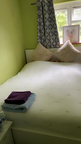 een slaapkamer met een wit bed en een raam bij 6 badger way in Hatfield